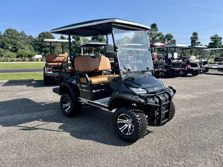 Black lifted golf cart with tan diamond stitched seats on a dealer lot