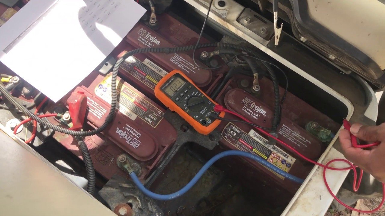 Multimeter checking rested voltage on a golf cart battery pack to expose a false full charge