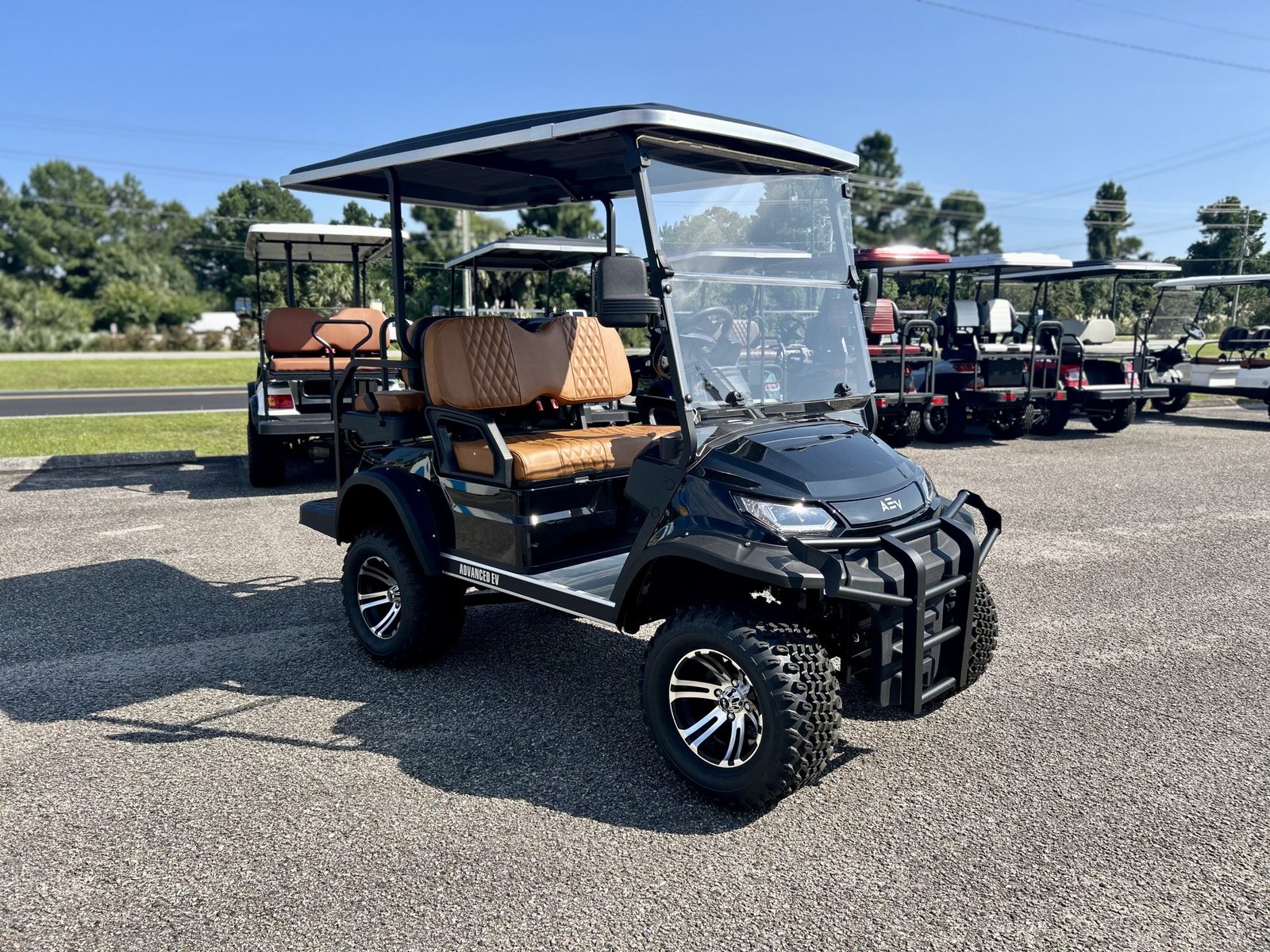 Lifted black Advanced EV Advent golf cart slow on hills, ADVANCED EV badging and off-road tires visible