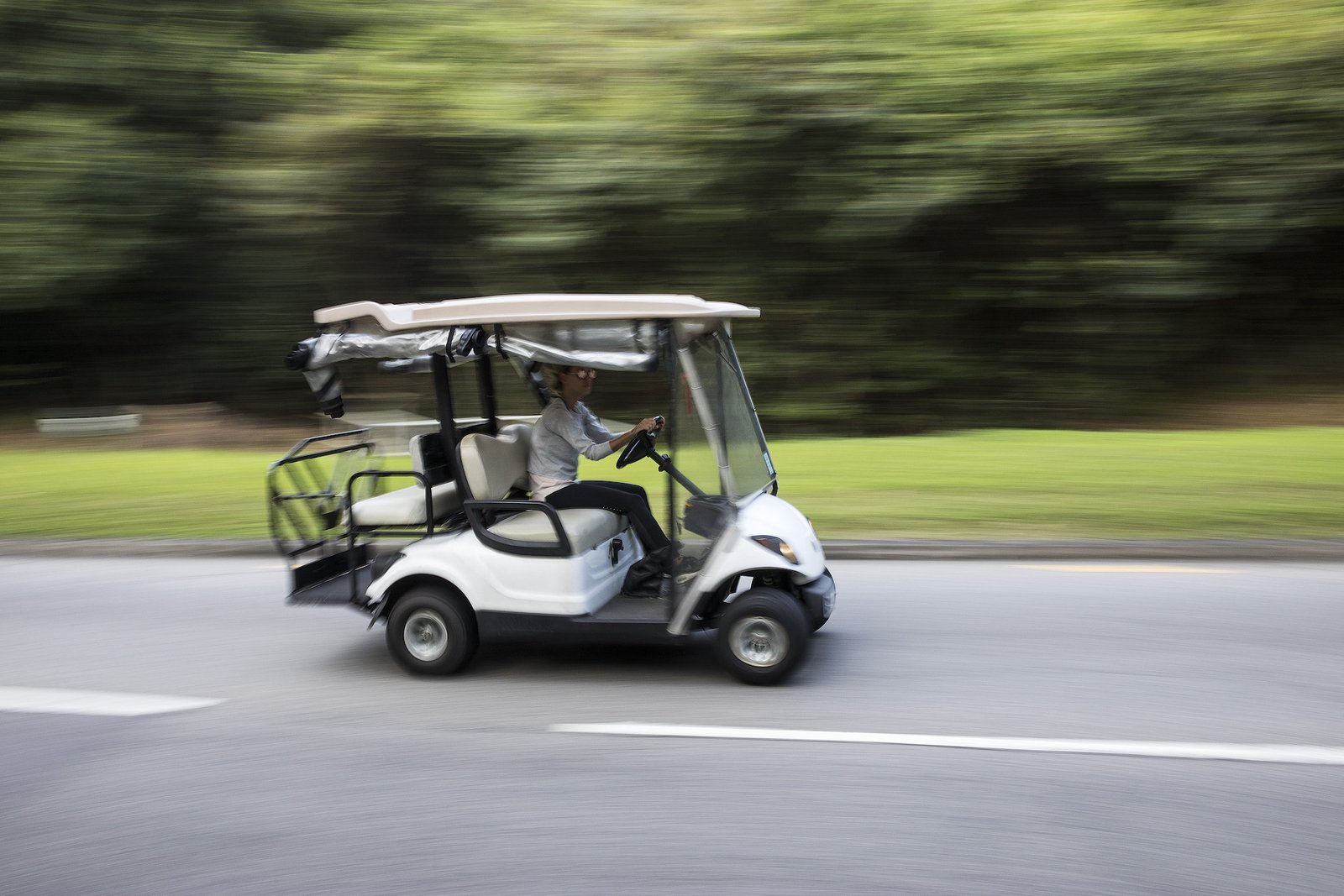 Street-legal golf cart on a road, illustrating golf cart top speed by brand and model